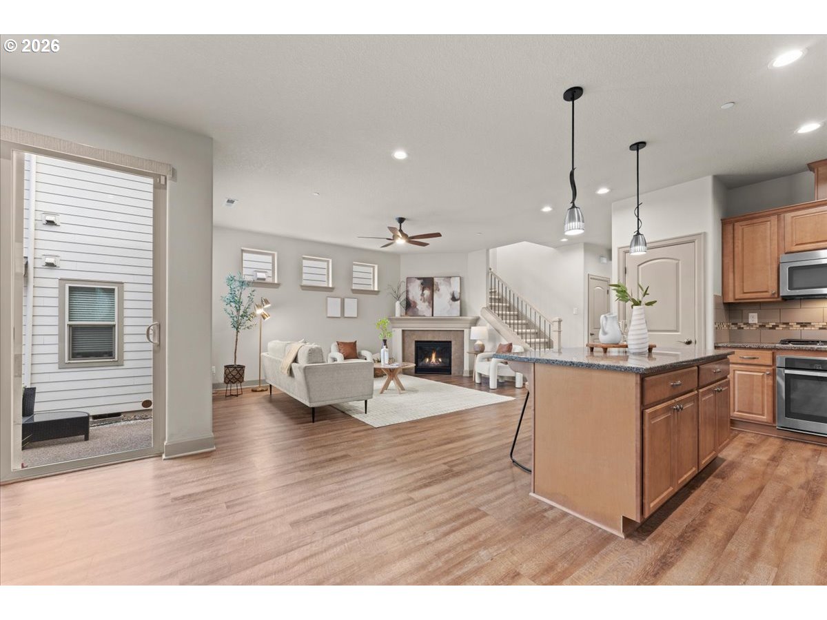 10899 Southwest Barber Street Wilsonville, OR 97070 - Photo 8 of 44 a living room with kitchen island furniture and a wooden floor