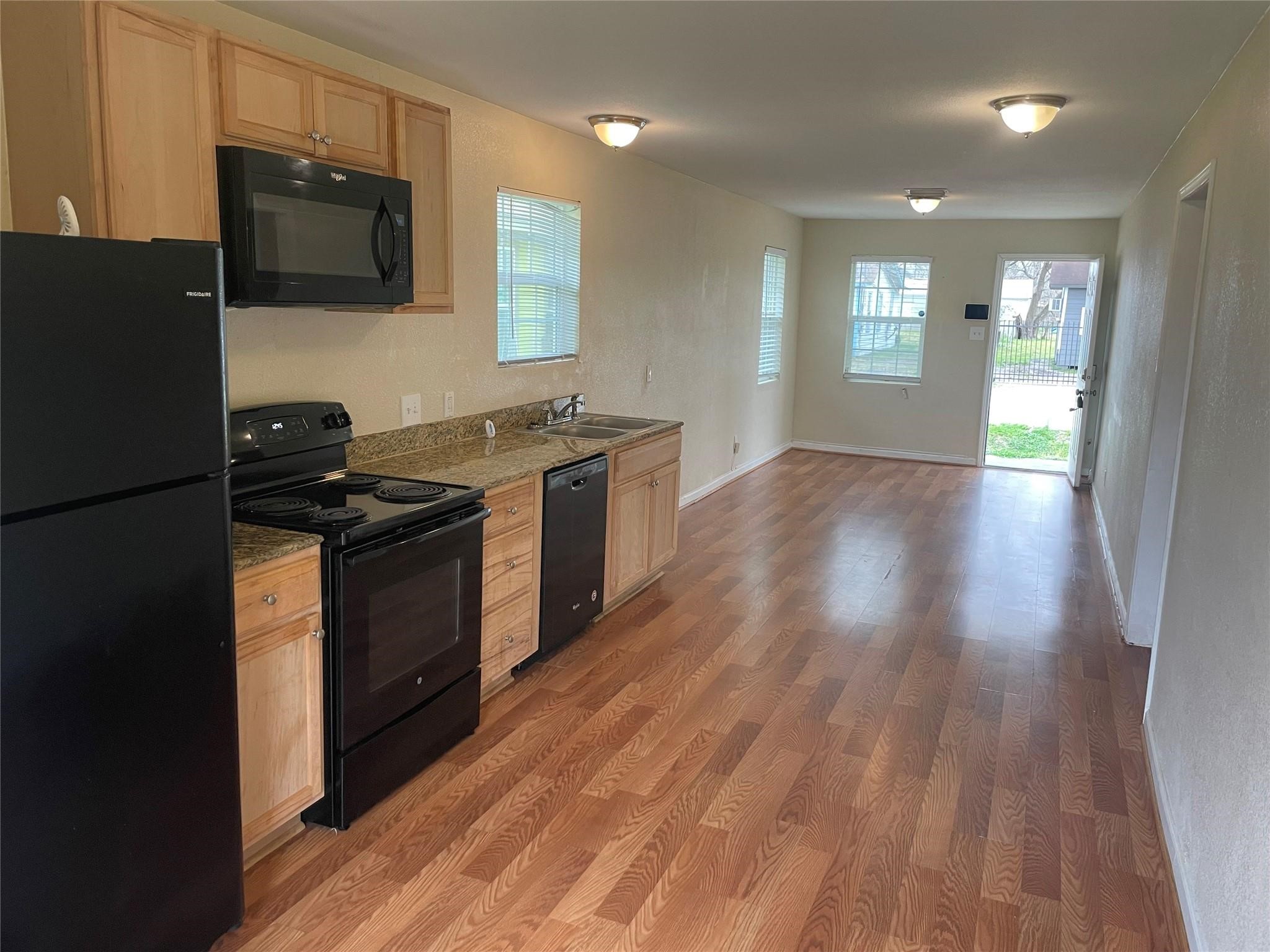 6315 Sayers Street Houston, TX 77026 - Photo 2 of 11 a kitchen with granite countertop a stove and a wooden floors