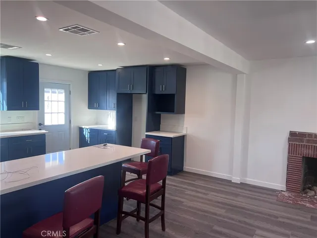 a kitchen with stainless steel appliances a dining table chairs and wooden floor
