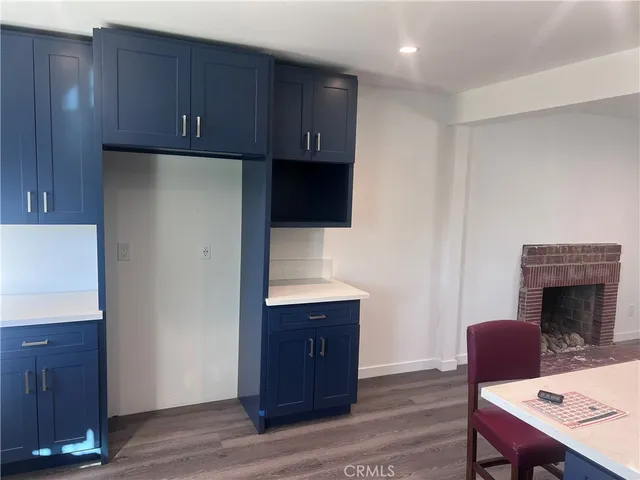 a kitchen with granite countertop a refrigerator a stove and wooden floor