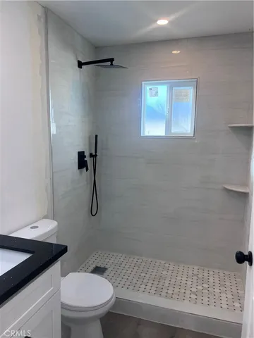 a bathroom with a granite countertop toilet a sink and shower