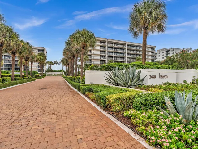 a view of a street with a flower garden and a wooden fence