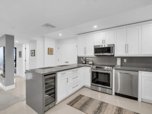 a kitchen with granite countertop white cabinets and stainless steel appliances