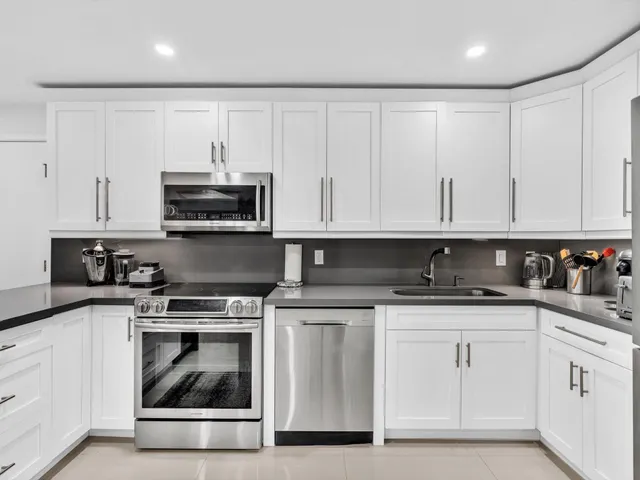 a kitchen with cabinets stainless steel appliances and sink