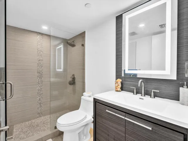 a view of a swimming pool with a bench and trees in the background