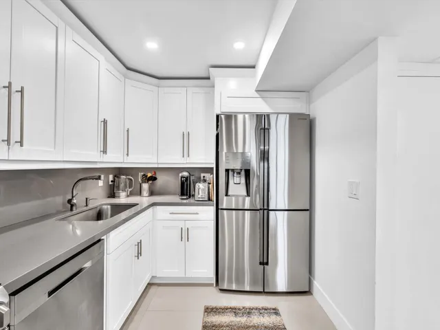 a view of a dining room and livingroom with furniture a rug a potted plant and a chandelier