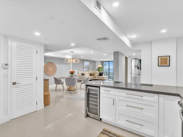 a kitchen with stainless steel appliances kitchen island granite countertop a refrigerator a stove a sink dishwasher and a refrigerator with wooden floor