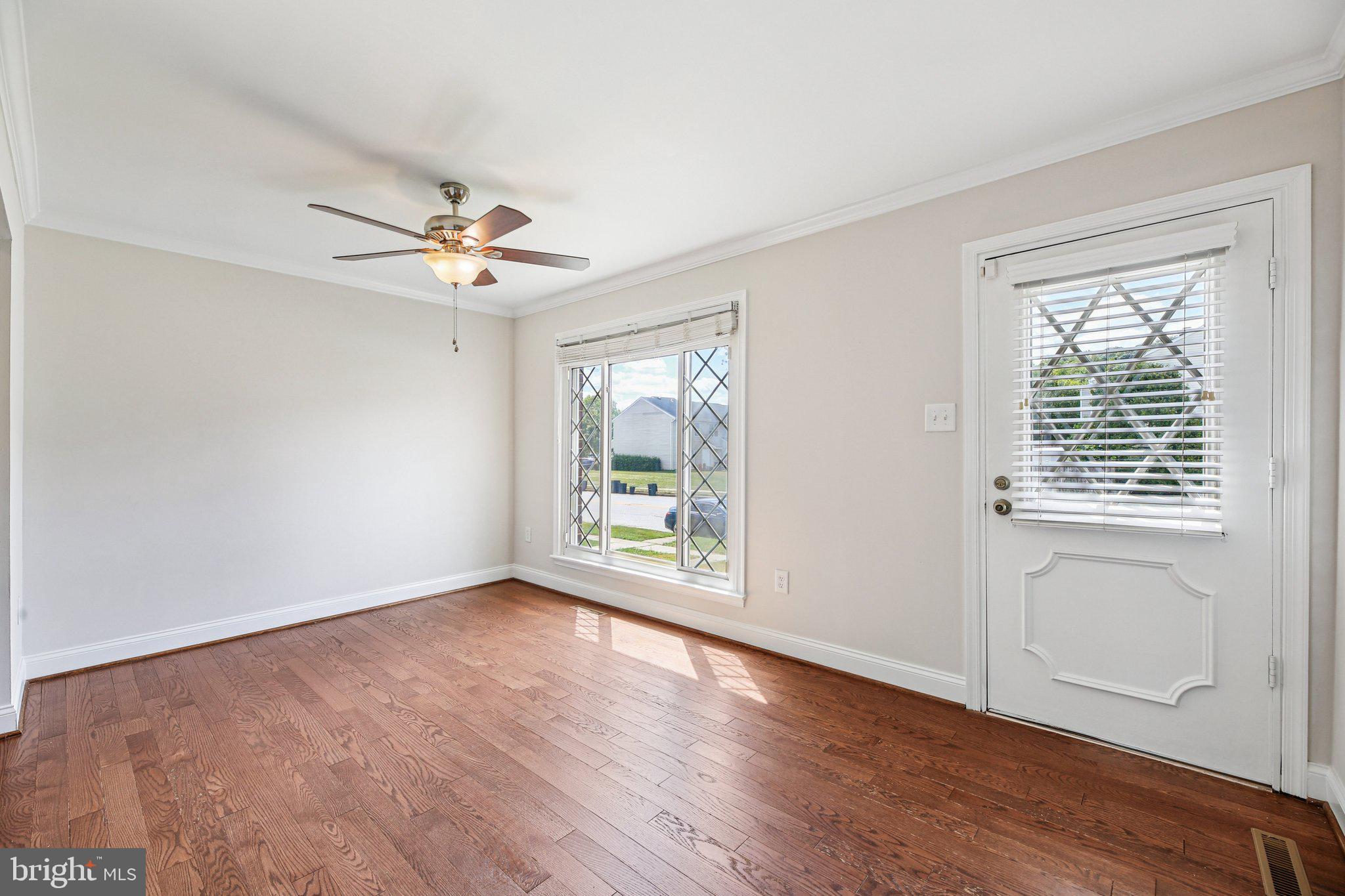 5603 Selford Road Baltimore, MD 21227 - Photo 4 of 31 a view of an empty room with a window and wooden floor