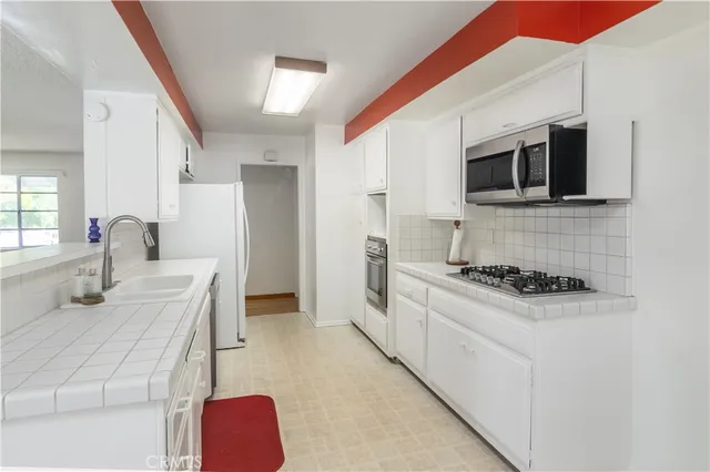 a kitchen with stainless steel appliances a stove microwave and sink