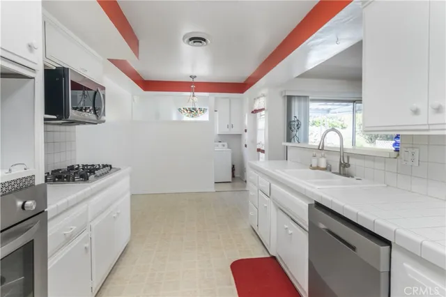 a kitchen with granite countertop a sink stainless steel appliances a counter space and a window