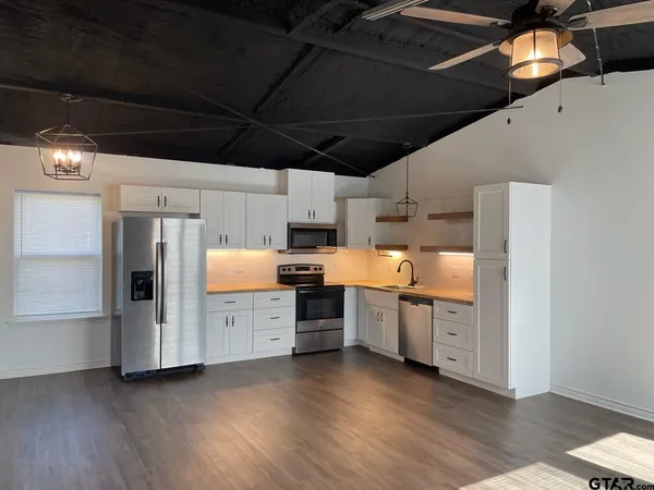 a kitchen with stainless steel appliances a stove a refrigerator and cabinets