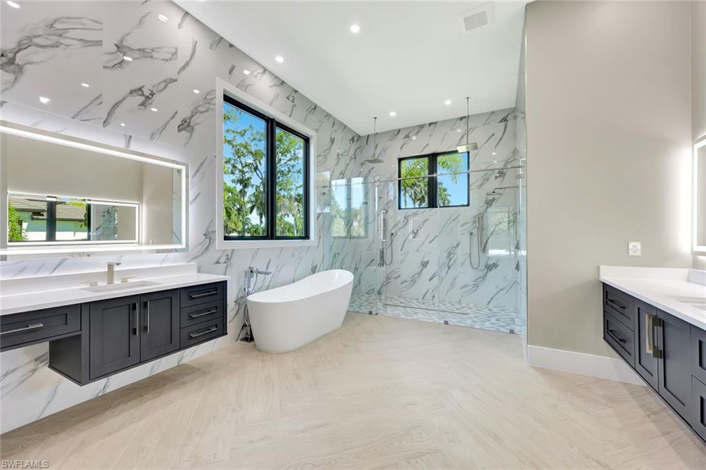 10493 Winterview Drive Naples, FL 34110 - Photo 12 of 40 a spacious bathroom with a tub sink shower and mirror