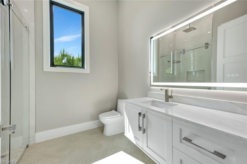 10493 Winterview Drive Naples, FL 34110 - Photo 19 of 40 a bathroom with a toilet sink and mirror