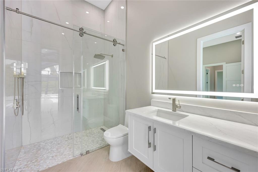 10493 Winterview Drive Naples, FL 34110 - Photo 23 of 40 a bathroom with a sink a toilet and shower