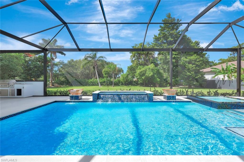 10493 Winterview Drive Naples, FL 34110 - Photo 31 of 40 a view of a swimming pool with a patio and a yard
