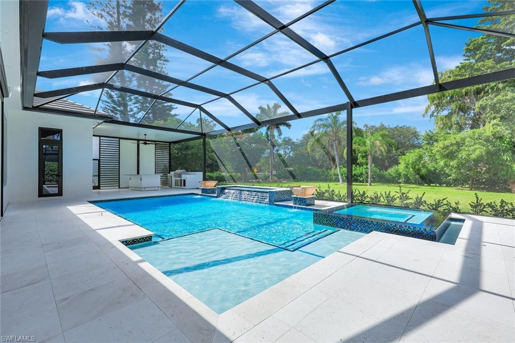10493 Winterview Drive Naples, FL 34110 - Photo 32 of 40 a view of a backyard with table and chairs under an umbrella