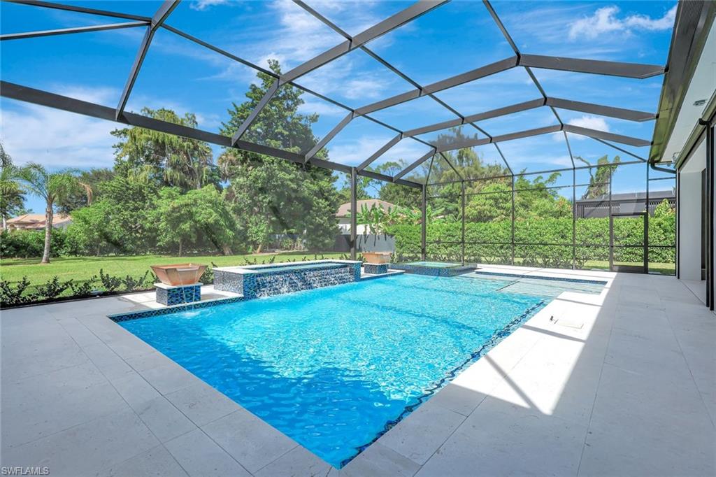 10493 Winterview Drive Naples, FL 34110 - Photo 33 of 40 a view of a backyard with table and chairs under an umbrella