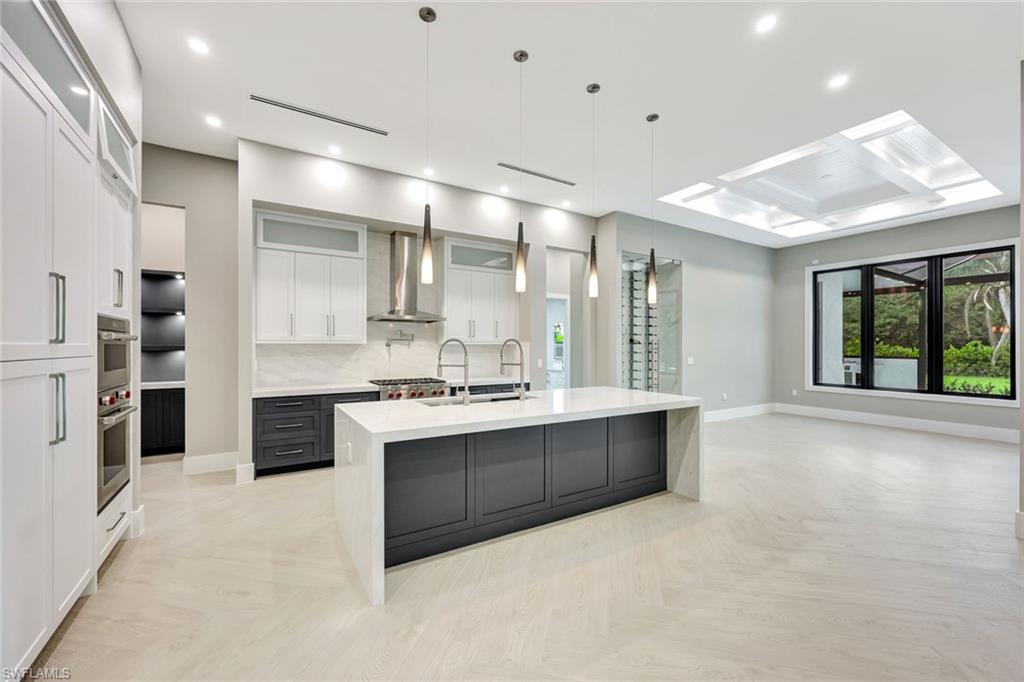 10493 Winterview Drive Naples, FL 34110 - Photo 7 of 40 a large kitchen with kitchen island a sink stainless steel appliances and cabinets