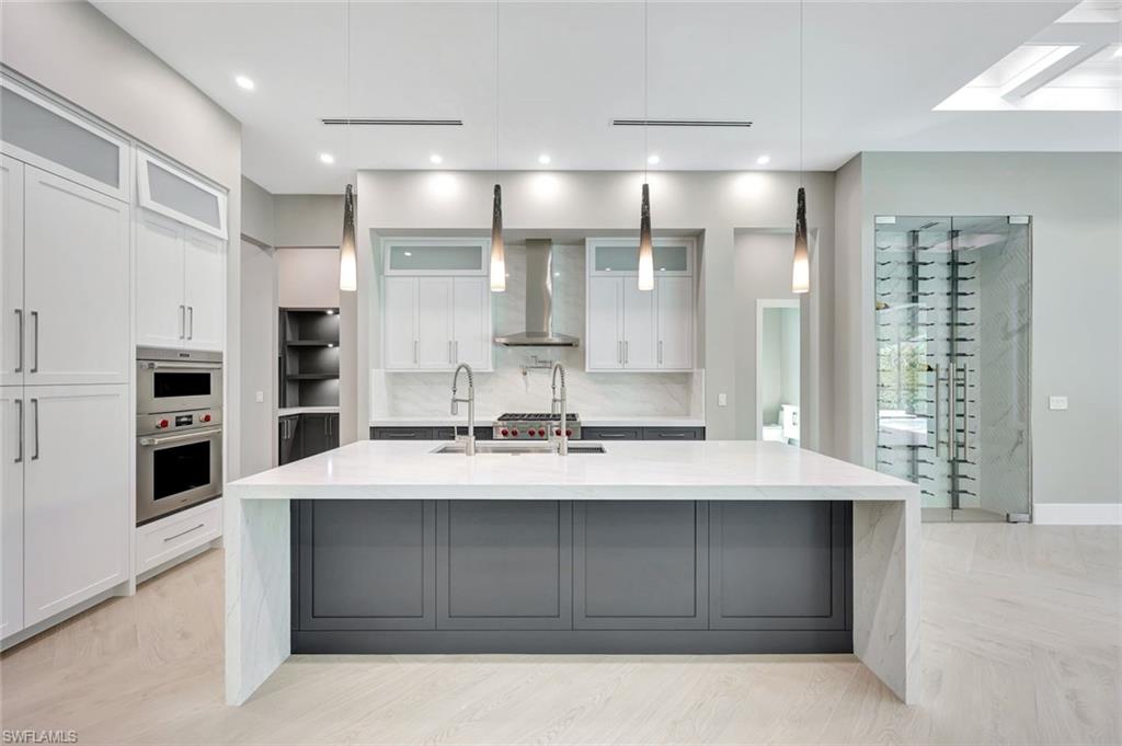 10493 Winterview Drive Naples, FL 34110 - Photo 9 of 40 a large kitchen with kitchen island a sink stainless steel appliances and cabinets