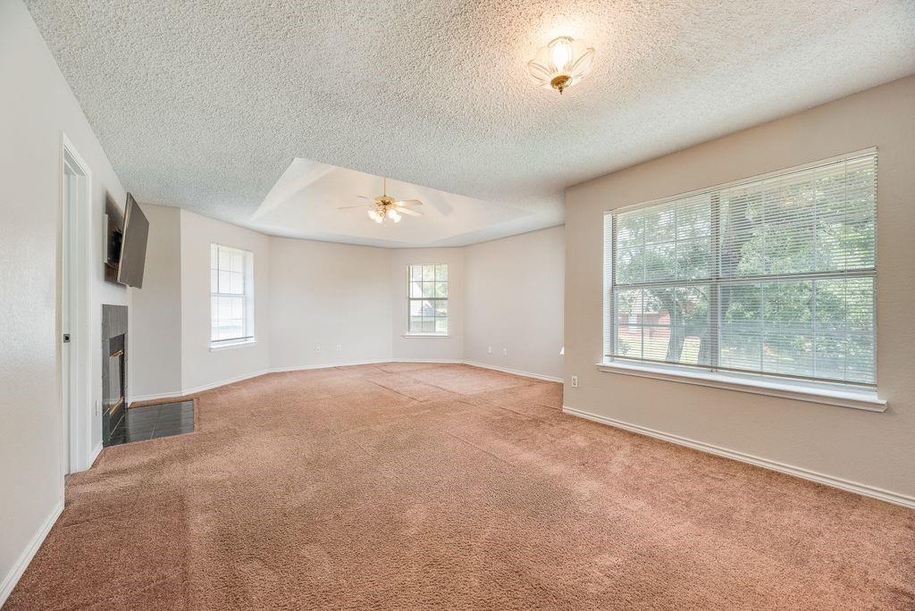 5610 Eagle Rock Road Arlington, TX 76017 - Photo 20 of 33 Spacious room featuring a tray ceiling, ceiling fan, and multiple windows with horizontal blinds