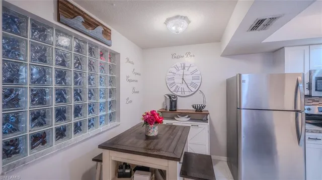 a kitchen with a refrigerator and a table chair