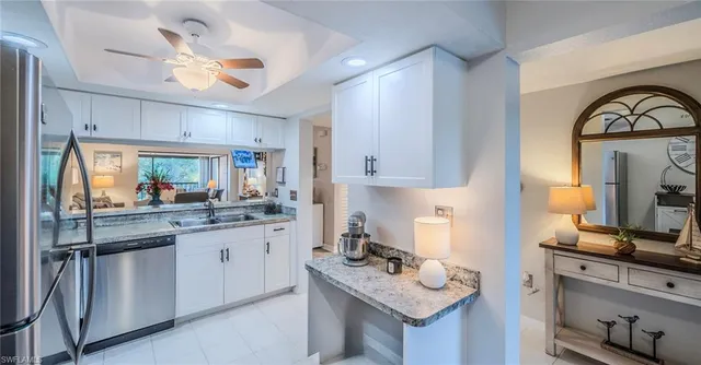 a kitchen with granite countertop a sink cabinets stainless steel appliances and a counter top space