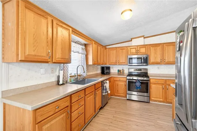 a kitchen with stainless steel appliances a stove sink and cabinets