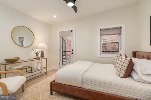 a bedroom with a bed a mirror and a window