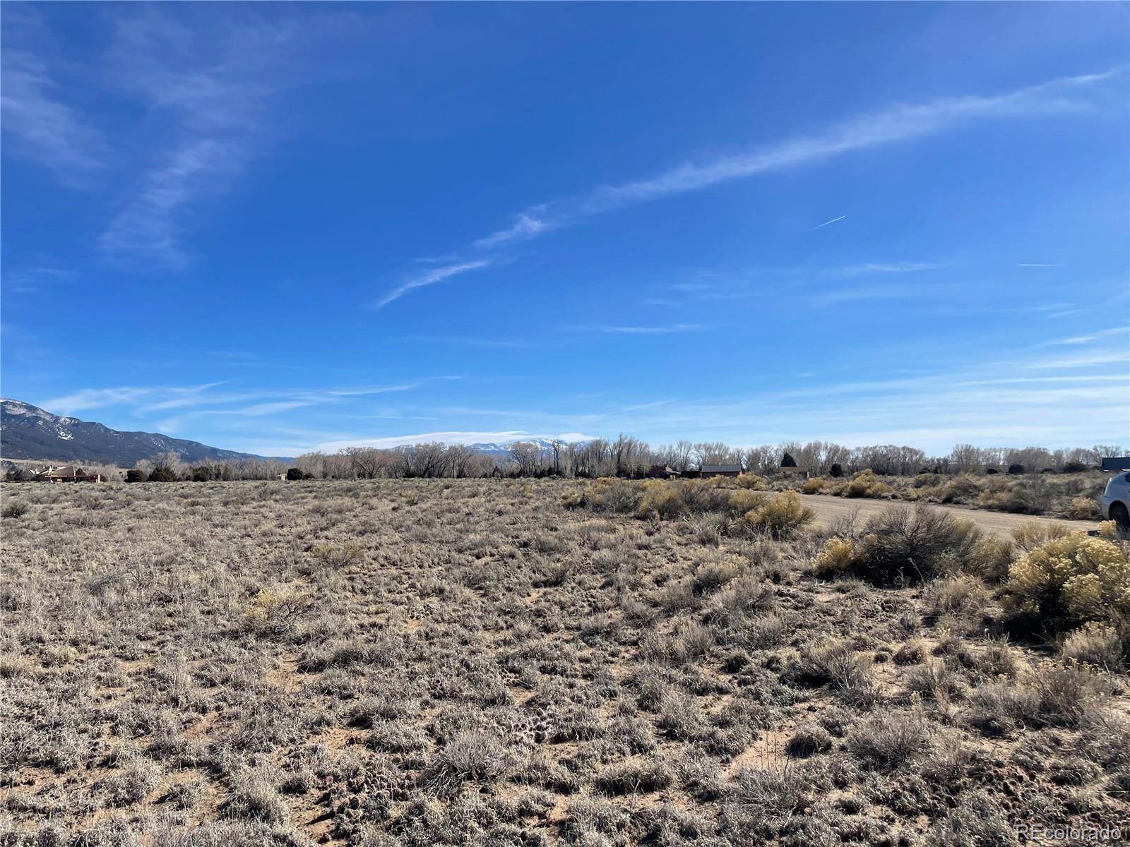 1402 Wagon Wheel Road Crestone, CO 81131 - Photo 2 of 10 a view of a large building with mountains in the background