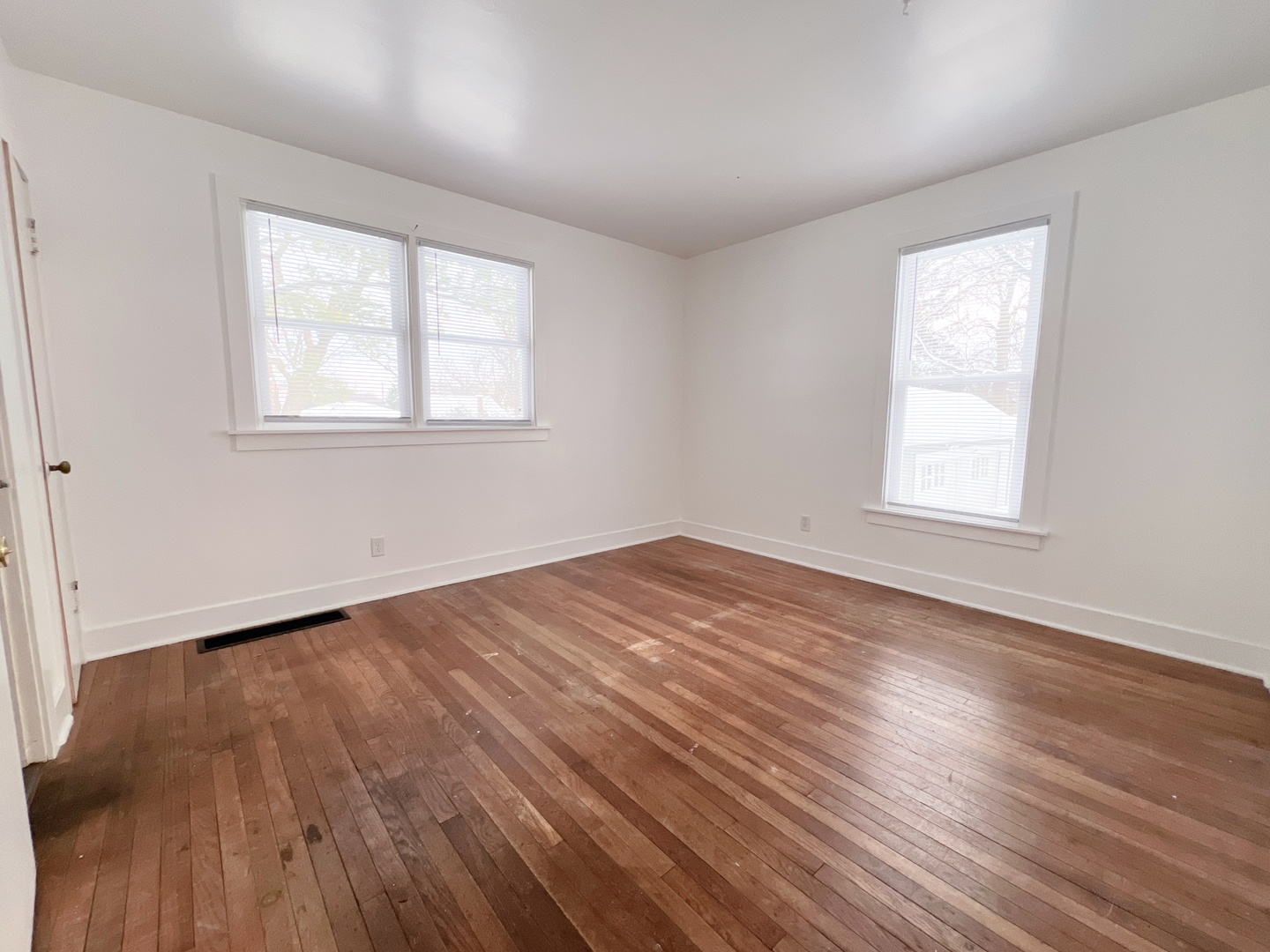 721 Dean Street, Unit 2 Woodstock, IL 60098 - Photo 11 of 17 a view of an empty room with wooden floor and a window