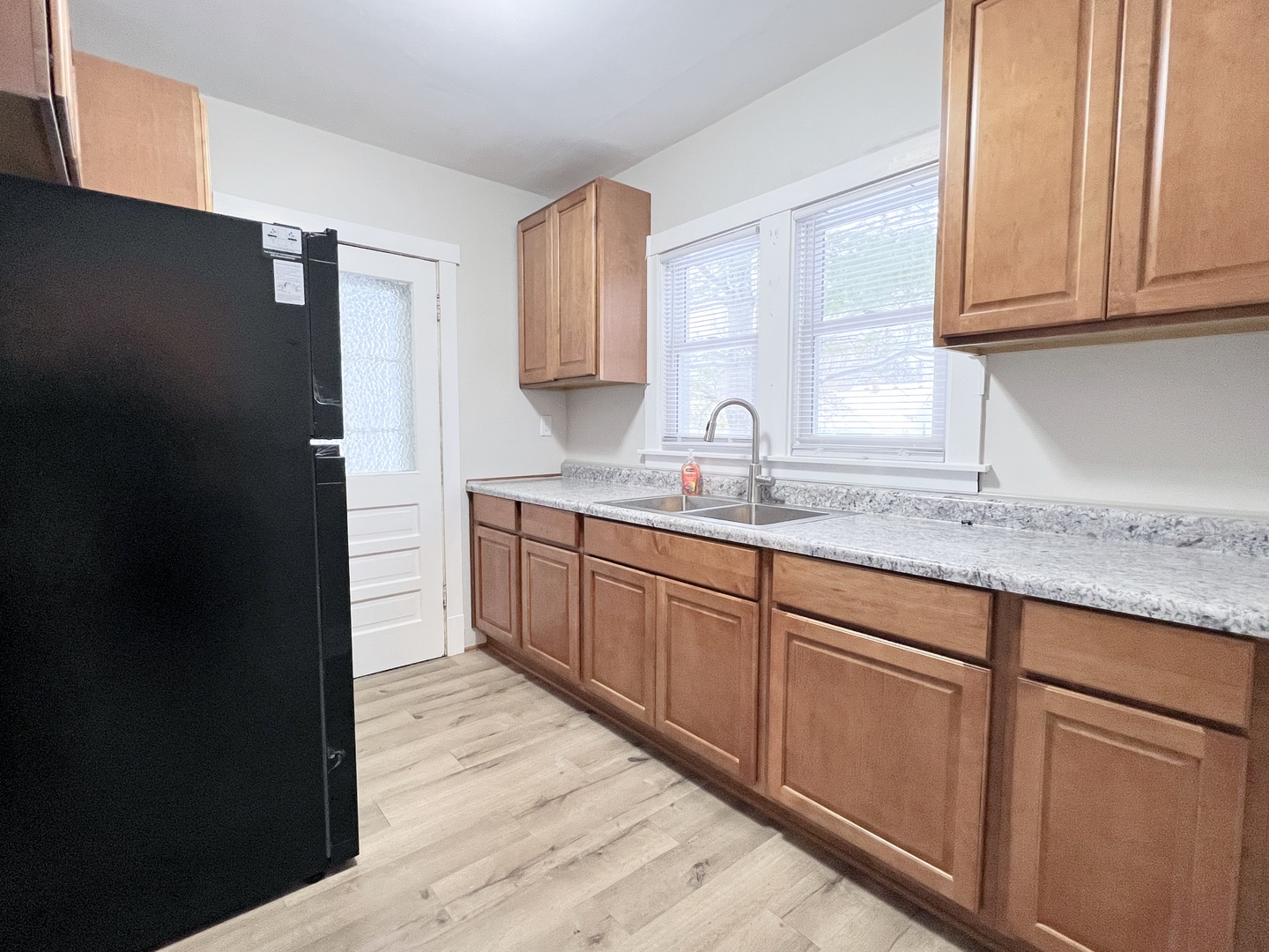 721 Dean Street, Unit 2 Woodstock, IL 60098 - Photo 4 of 17 a kitchen with granite countertop cabinets sink and window