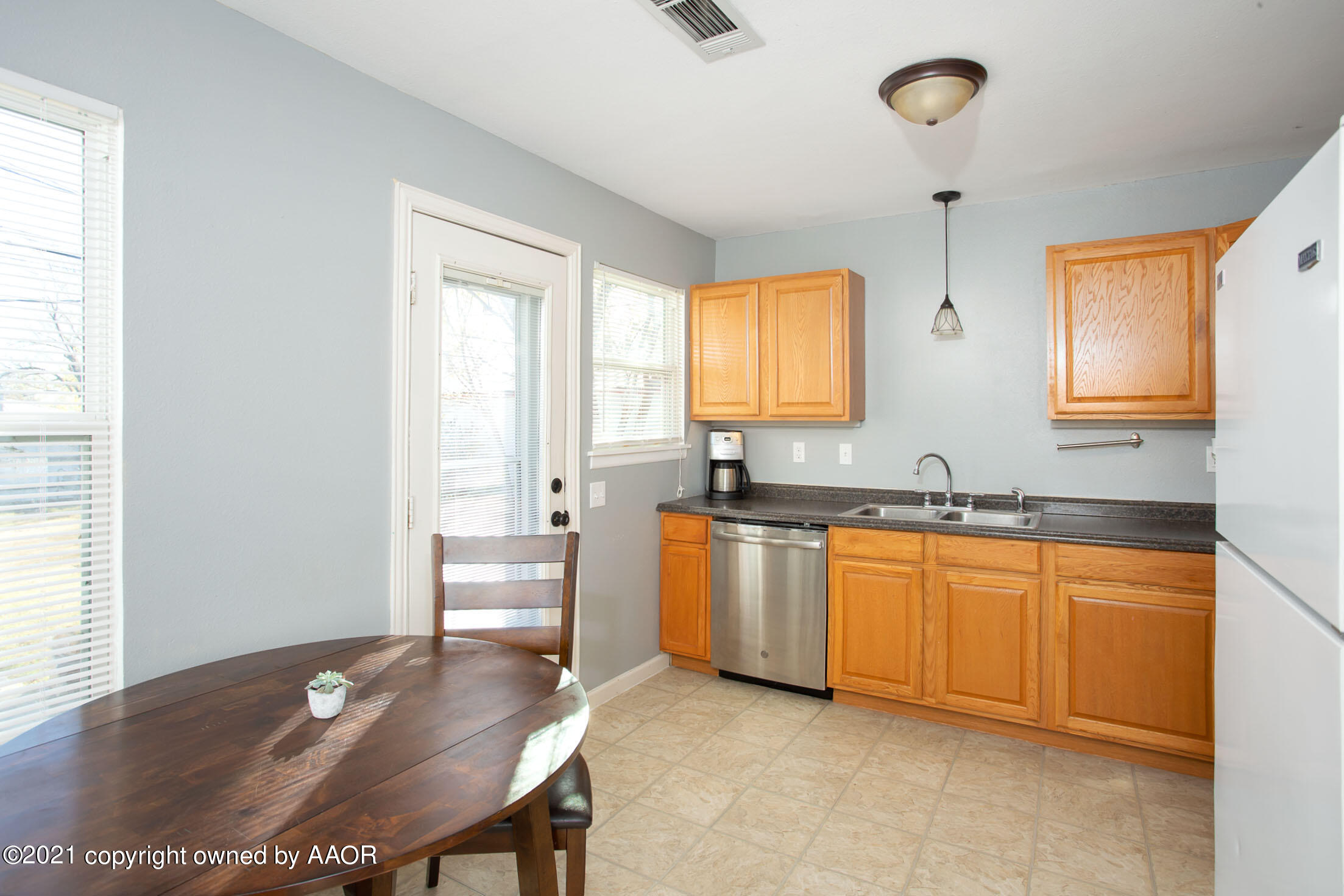 3807 South Jackson Street Amarillo, TX 79110 - Photo 6 of 17 a room with stainless steel appliances granite countertop a sink wooden cabinets and a window