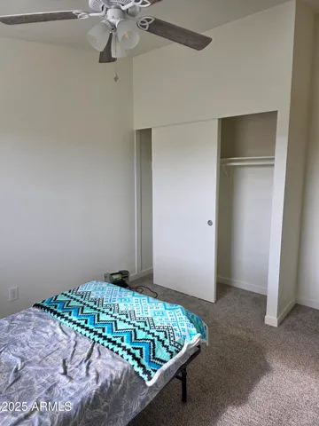 a bedroom with a bed and a chandelier fan