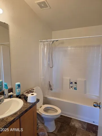 a bathroom with a granite countertop sink toilet mirror and shower