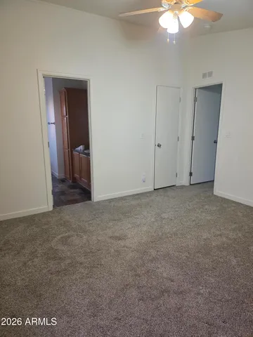 a view of an empty room with a chandelier fan