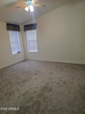 an empty room with windows and fan