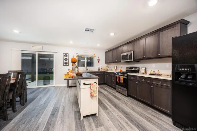 a large kitchen with stainless steel appliances and wooden cabinets