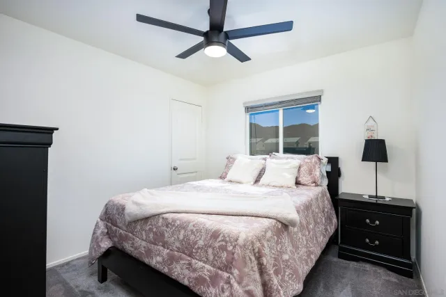 a bedroom with a bed and a flat tv screen on the dresser
