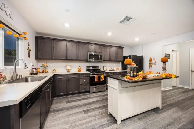 a kitchen with stainless steel appliances granite countertop a sink stove and refrigerator