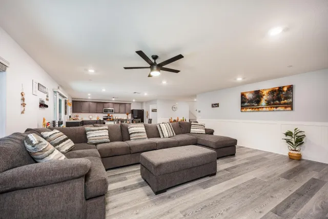 a living room with furniture kitchen view and a window