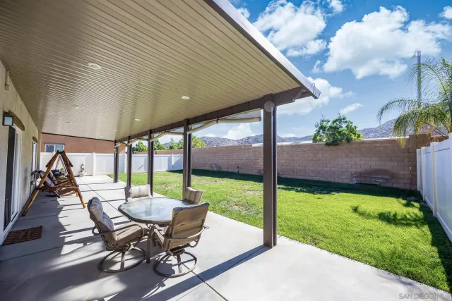 a view of a patio with a table chairs and a backyard