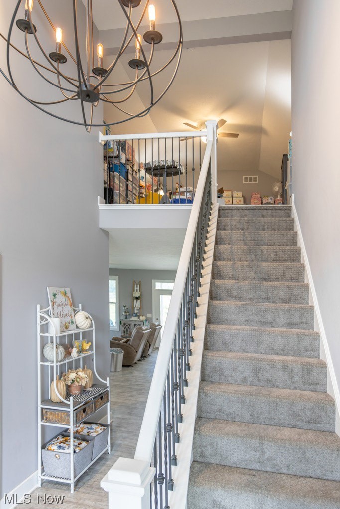 8341 Ickes Road Wooster, OH 44691 - Photo 13 of 34 Stairs featuring wood-type flooring, a chandelier, and lofted ceiling