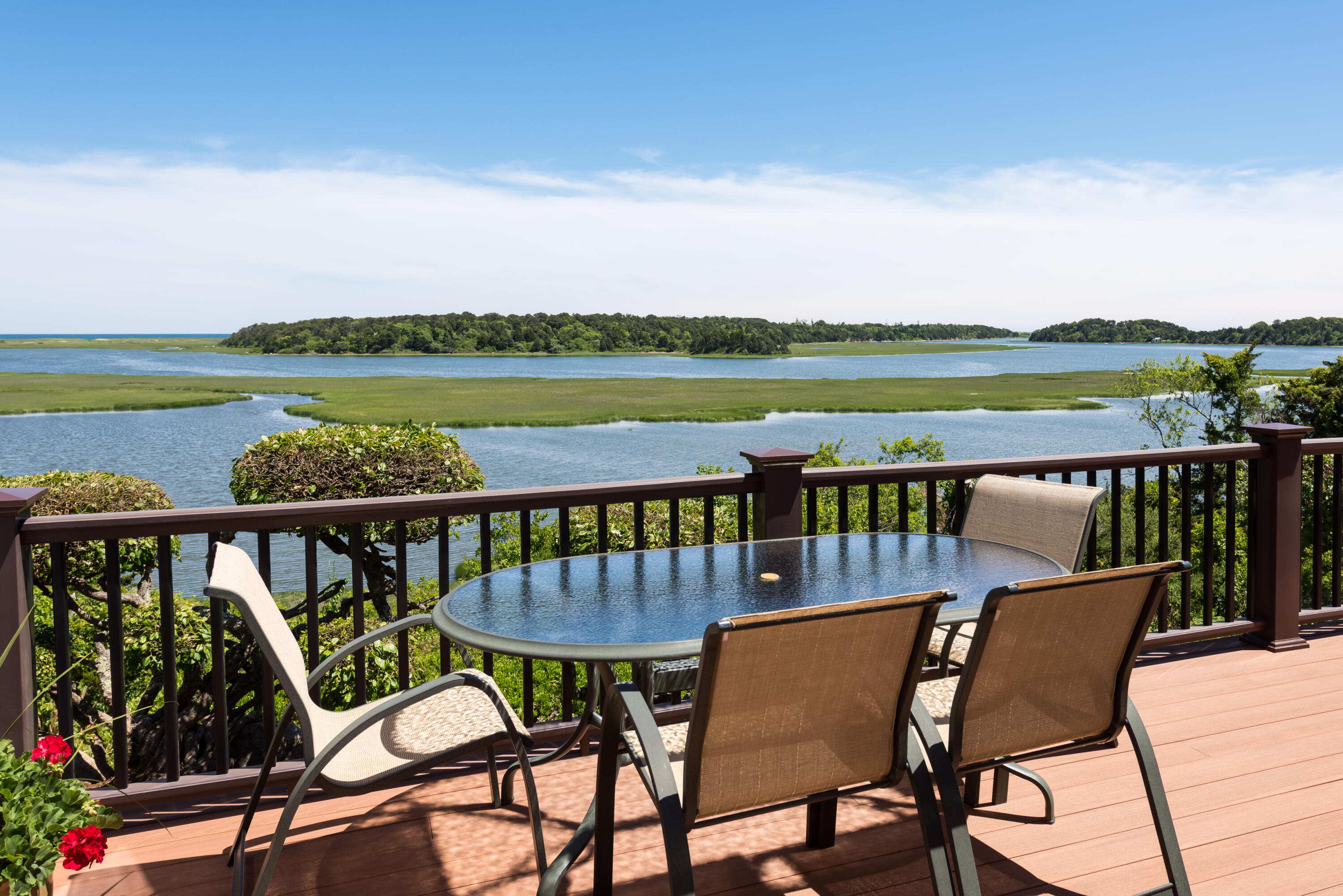 71 Briar Spring Road Orleans, MA 02653 - Photo 2 of 45 a view of a balcony with wooden chairs and a ocean view