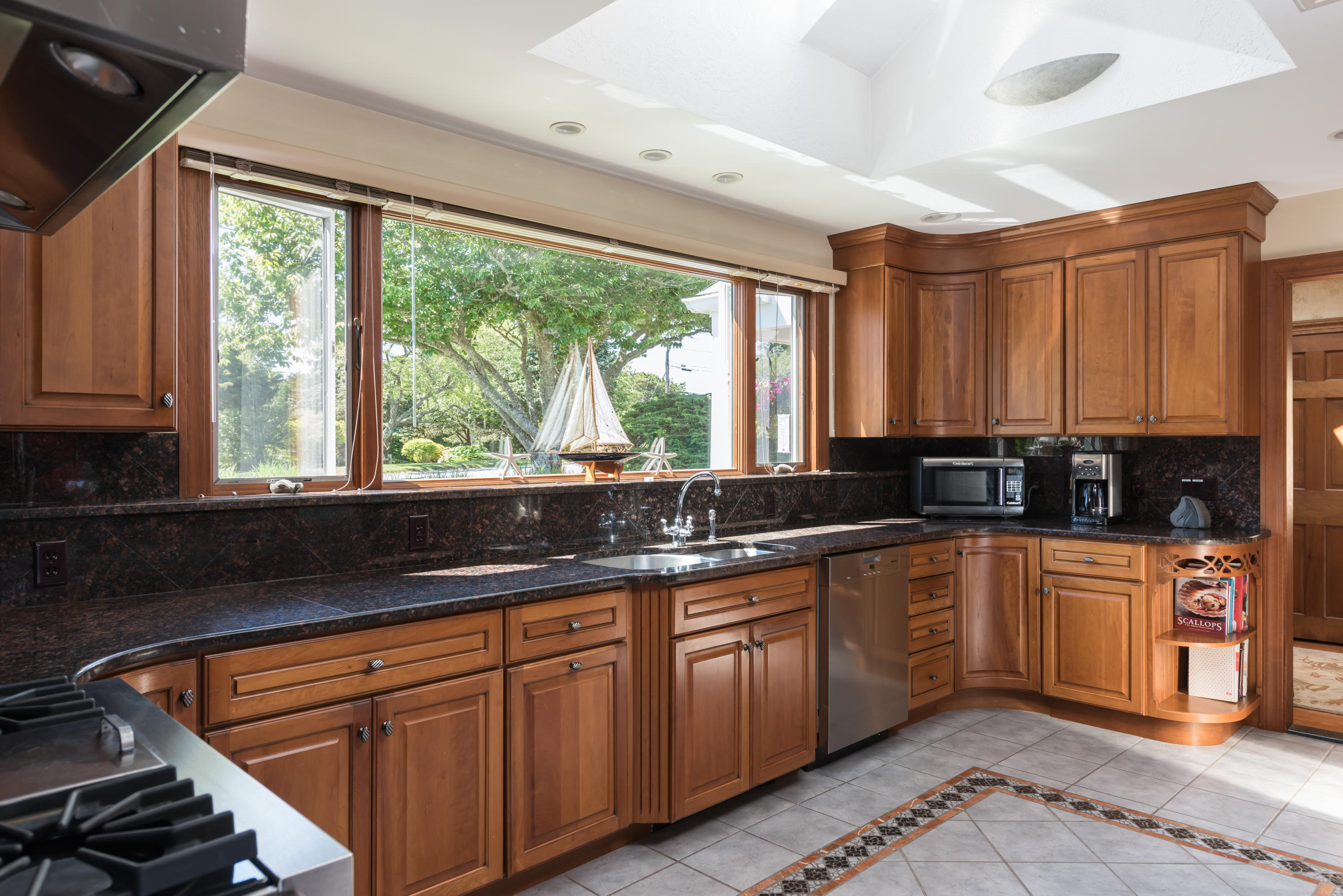 71 Briar Spring Road Orleans, MA 02653 - Photo 30 of 45 a kitchen with stainless steel appliances granite countertop a stove a sink and a granite counter tops with white cabinets
