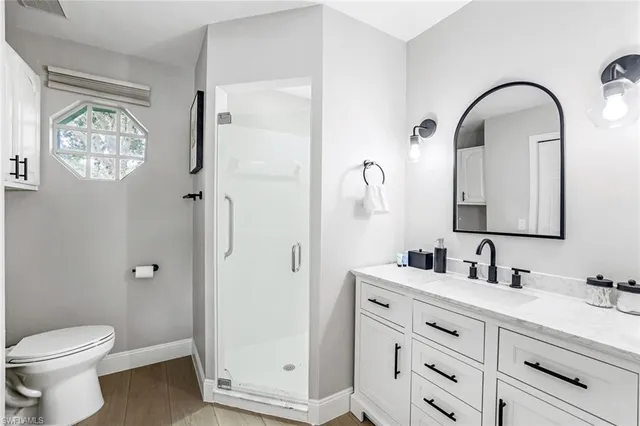 a bathroom with a double vanity sink a toilet and a mirror
