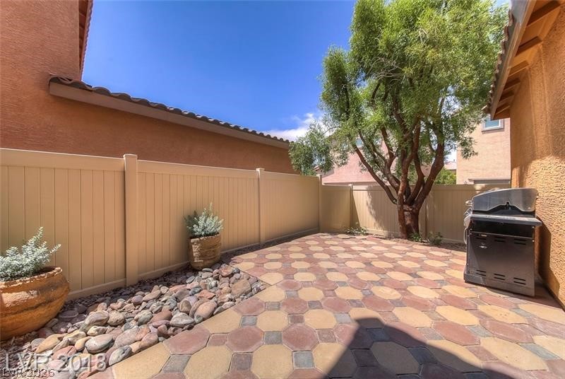 3144 Whitfeild Avenue Henderson, NV 89044 - Photo 31 of 55 A private outdoor space with a patterned paver patio and mature tree, ideal for entertaining.