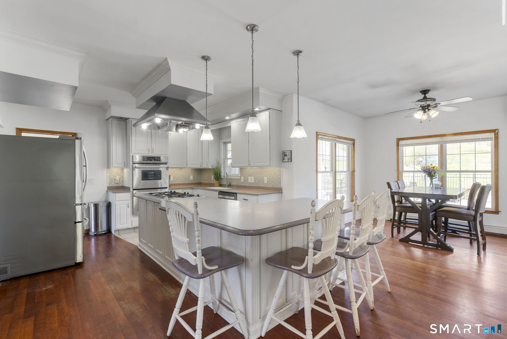 341 High Street Extension Thomaston, CT 06787 - Photo 7 of 39 a kitchen with stainless steel appliances kitchen island granite countertop a stove a refrigerator a dining table and chairs with wooden floor