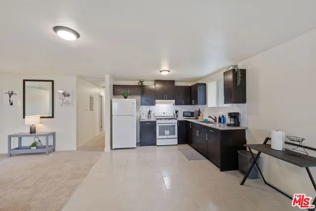 a kitchen with stainless steel appliances kitchen island granite countertop a refrigerator stove top oven and sink