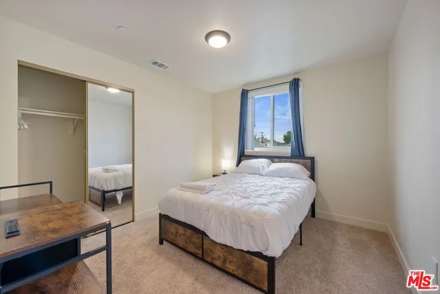 a bedroom with a bed and a lamp on the table