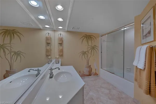 a spacious bathroom with a double vanity sink a mirror and a shower